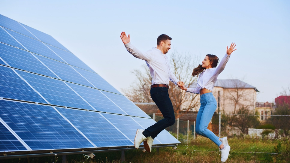 mlad sretan par ispred solarnih panela