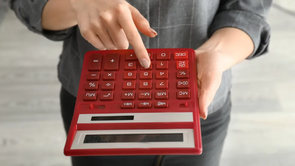 Osoba nam pred nosom moli crveni kalkulator.