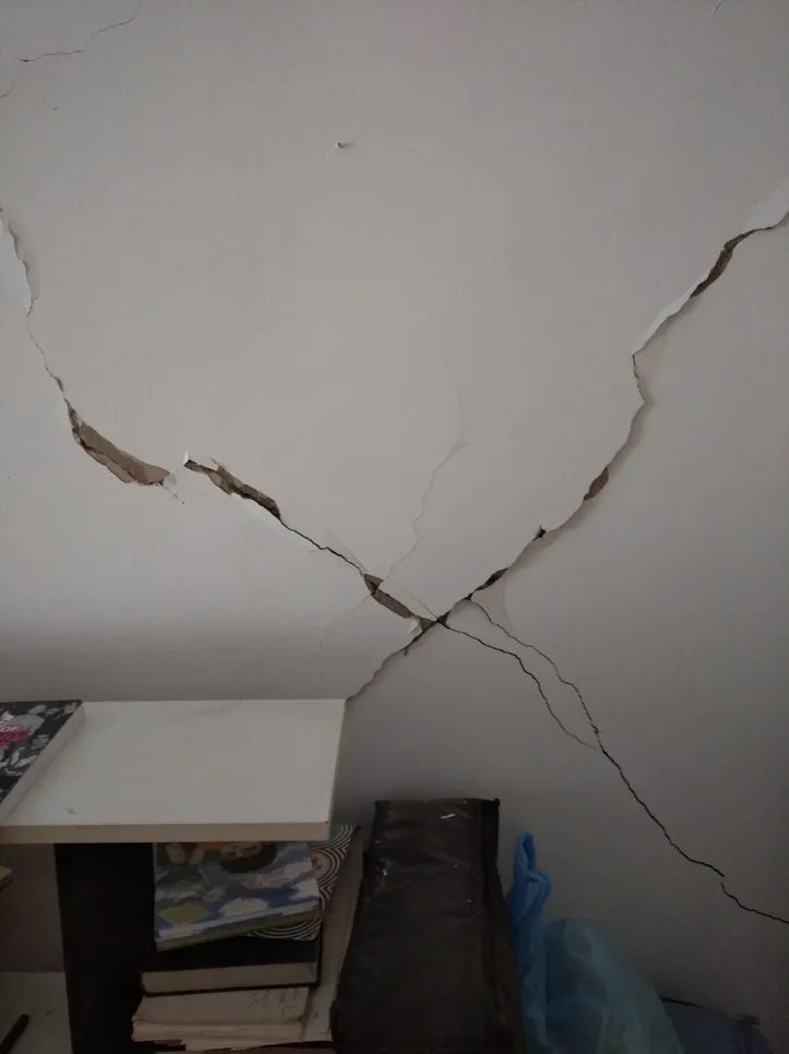 Large cracks across a residential interior wall indicating potential structural issues.