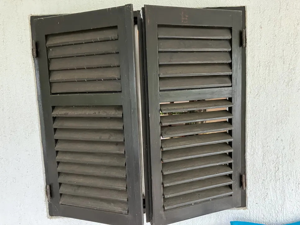Old wooden shutters with signs of wear and damaged slats needing restoration or replacement.