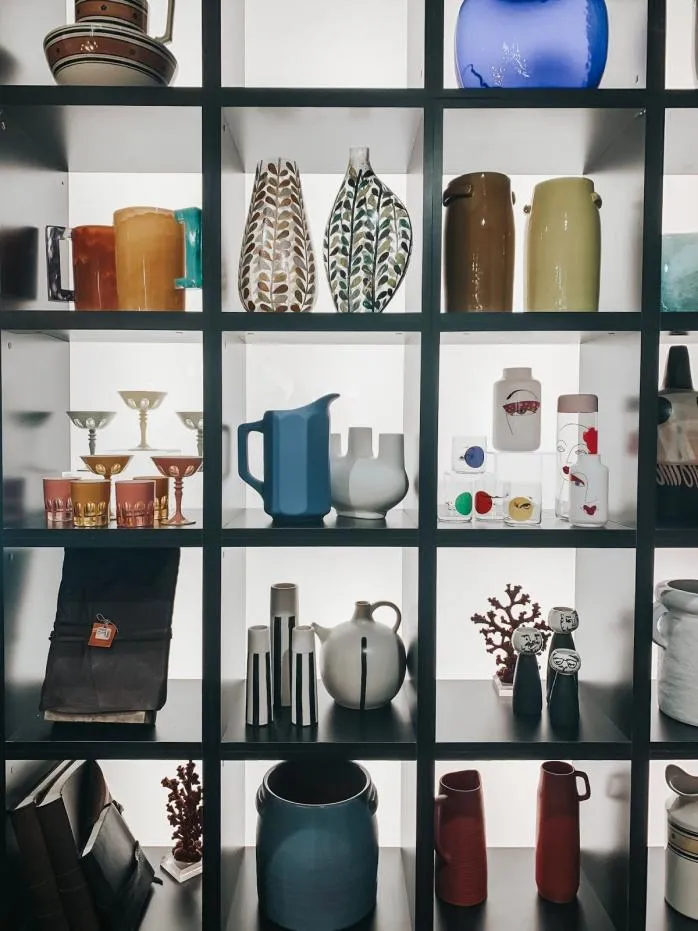 Pregrada u kuhinji s policama punim različitih vaza.
