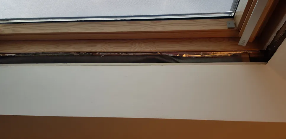 Otkriveni razmak u drvenom okviru prozora, ističući potencijalne probleme s izolacijom ili vlagom.