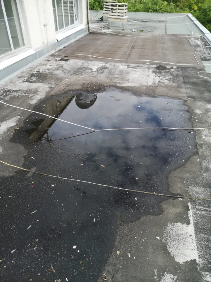 Water accumulation on a flat roof, potentially causing structural issues or leaks.