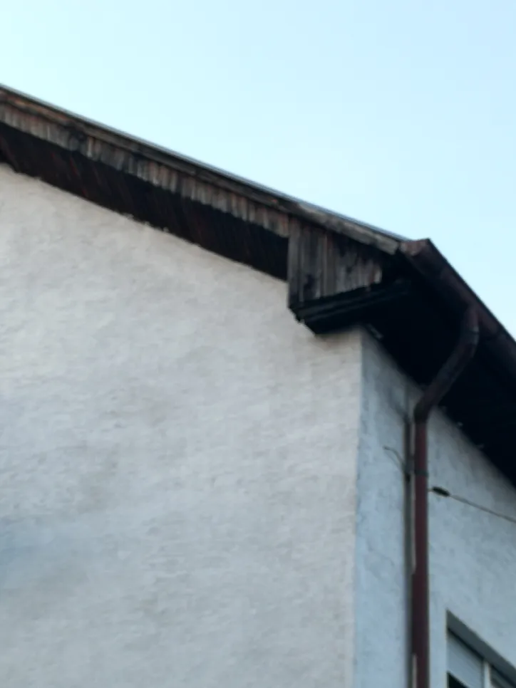 Krov s vidljivim olucima i odvodnim cijevima koji ukazuju na moguću potrebu za inspekcijom ili održavanjem.