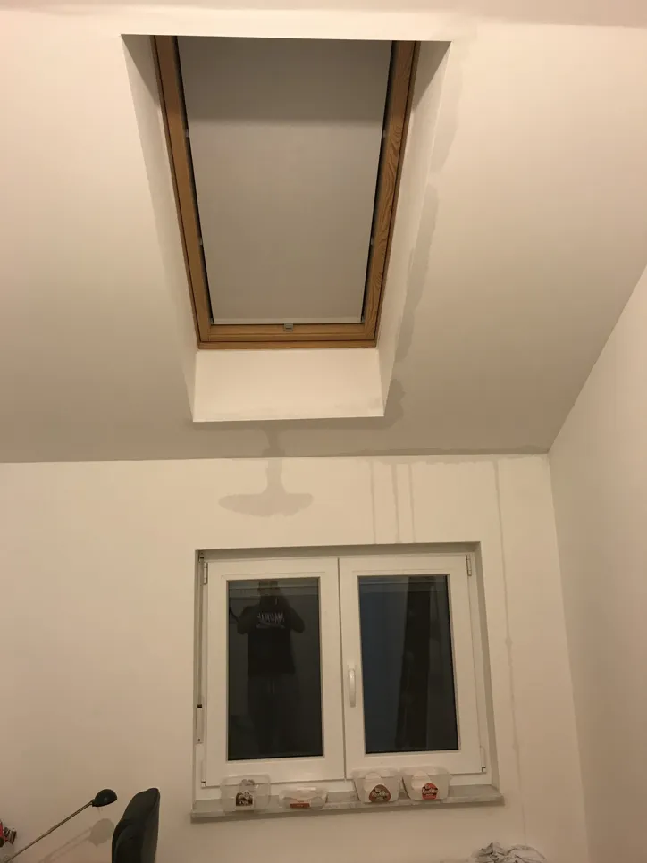 Prozorski otvor s mrljama od vode i promjenom boje stropa koja ukazuje na moguće probleme s curenjem.