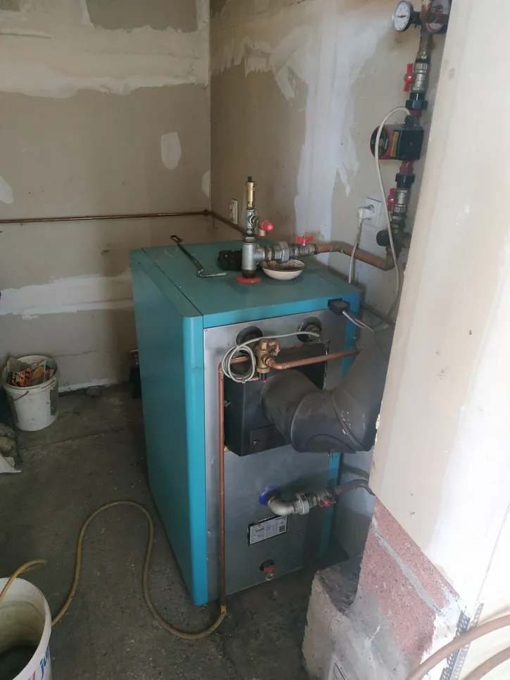 Postavka stambenog bojlera s vidljivim bakrenim cijevima i industrijskim komponentama u tehničkoj prostoriji.